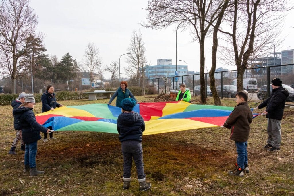einsmehr Gruppe 6-12 Jahre steht im Kreis um ein Schwungtuch