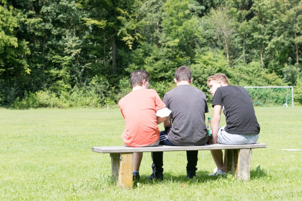 Drei Jugendliche sitzen auf einer Bank bei einsmehr Aktionswochenende
