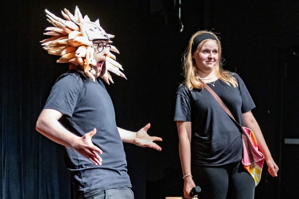 einsmehr Gruppe FreiSpiel21, ein Mann als Löwe verkleidet und eine Frau auf der Bühne