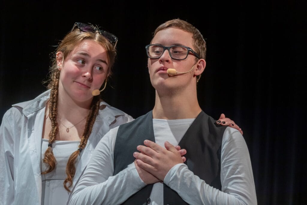 Zwei Mitglieder der einsmehr Gruppe FreiSpiel21 auf der Bühne