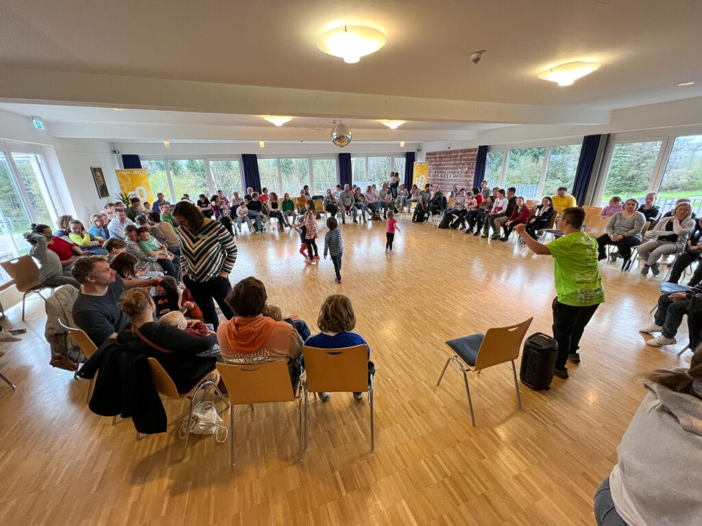 Alle Teilnehmer des Familienwochenendes treffen sich im großen Saal