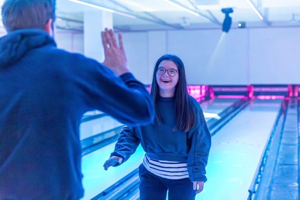 Frau der Gruppe Gästeliste einsmehr beim Bowling