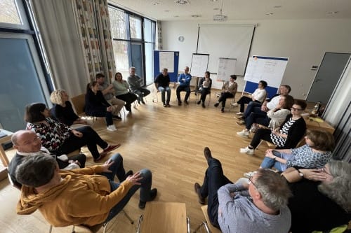 einsmehr Gruppe sitzt zur Besprechung im Stuhlkreis