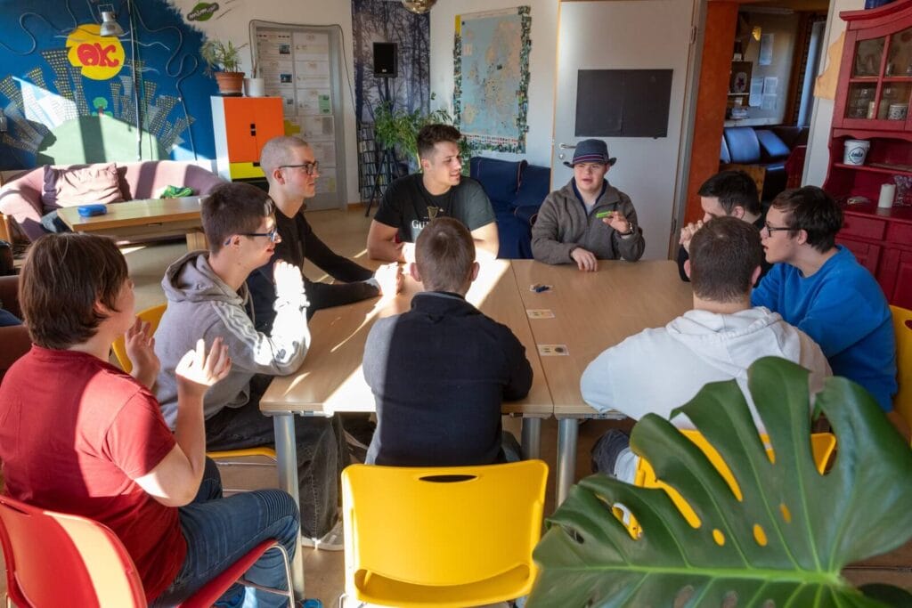 einsmehr Jungsgruppe sitzt um einen Tisch