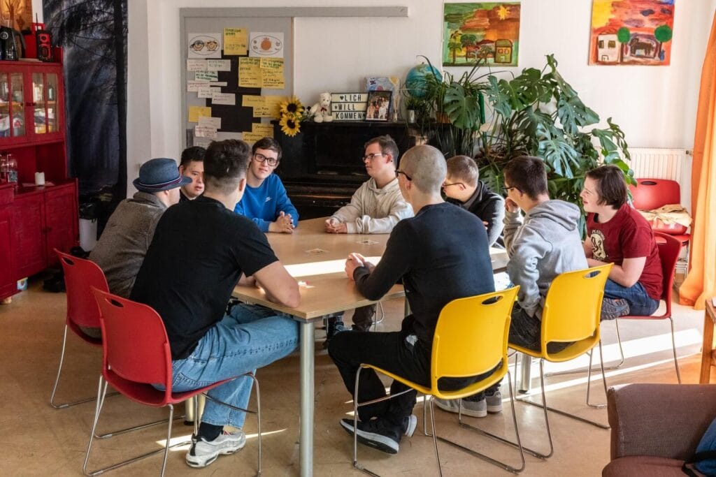 einsmehr Jungsgruppe sitzt um einen Tisch