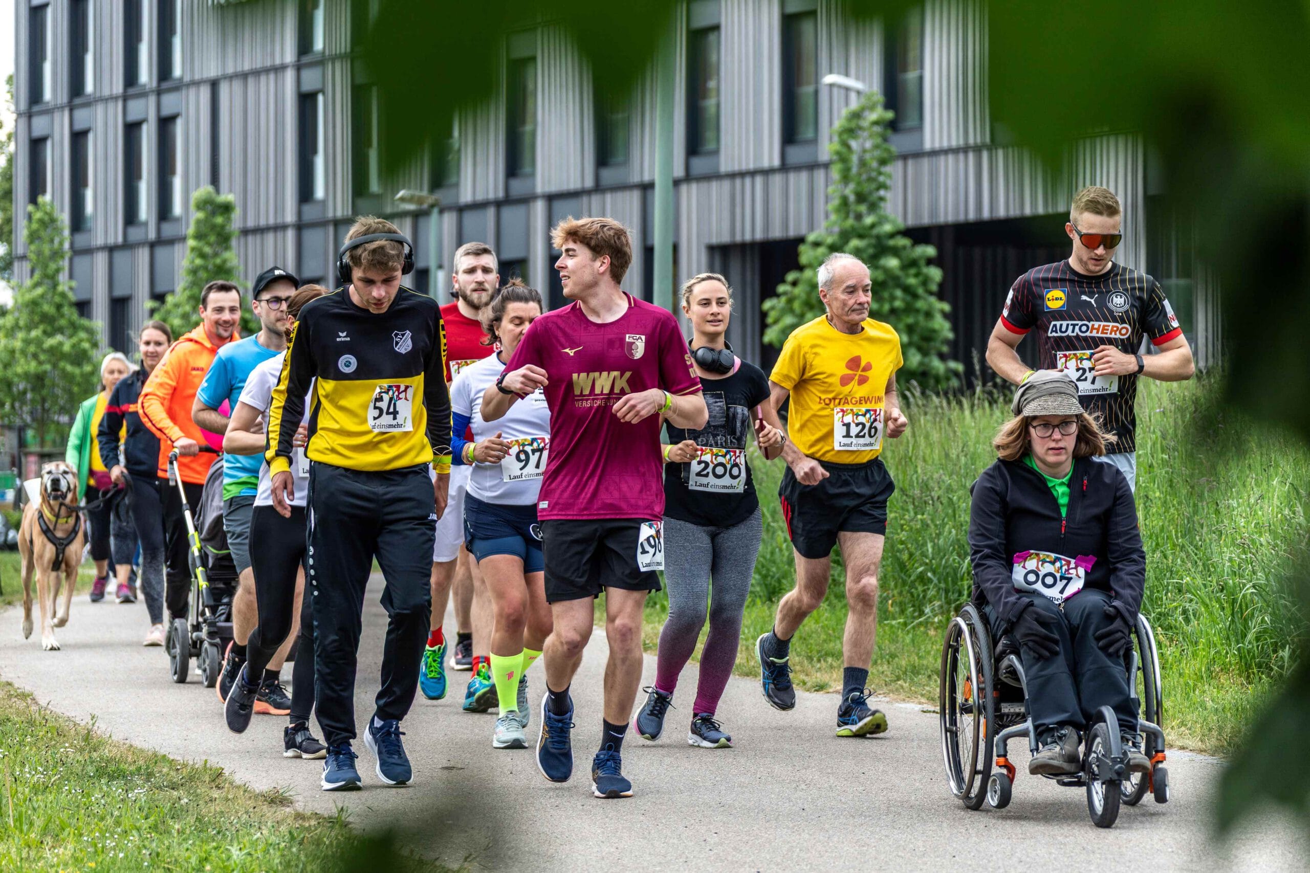 Läuferinnen und Läufer des Lauf einsmehr 2025 vor dem Hotel einsmehr in Augsburg