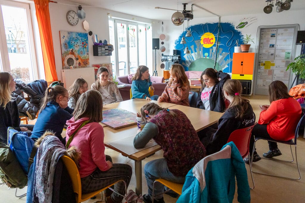 Starke Mädchen Gruppe sitzt um einen Tisch