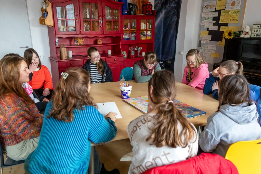 Starke Mädchen Gruppe sitzt um einen Tisch