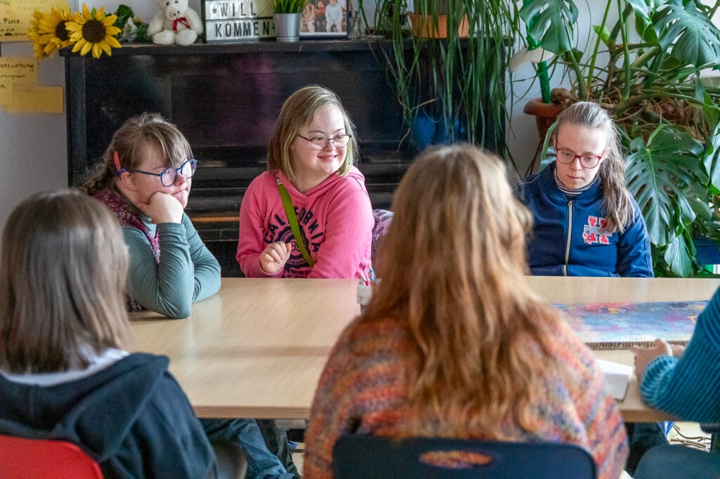 Starke Mädchen sitzen um einen Tisch