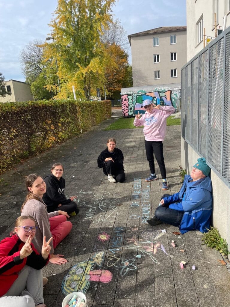 Gruppe von Mädchen hat mit Straßenkreide gemalt und geschrieben